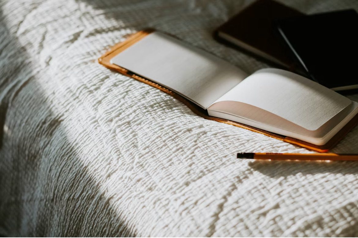 Image shows an open notebook on a bed 