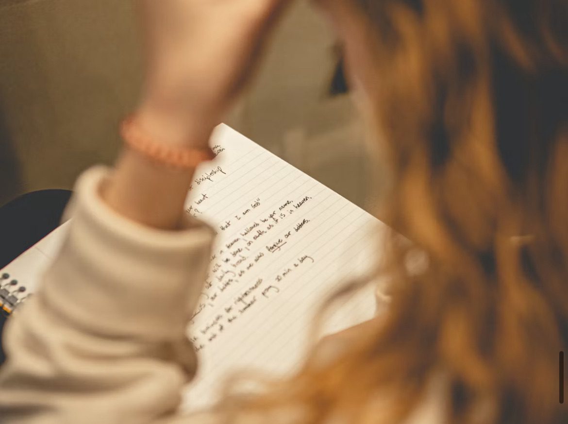 Journaling for anxiety. Image shows a woman looking at a journal 