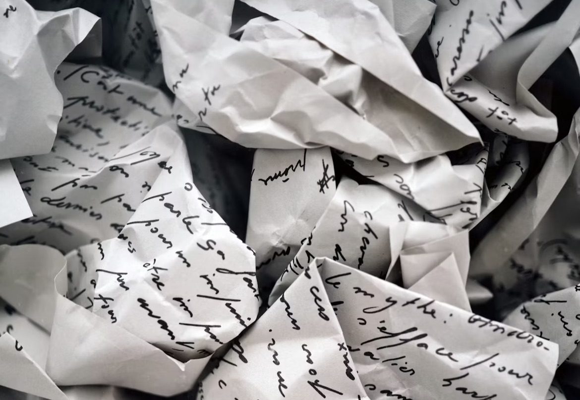 Image shows lined paper with writing crumpled up