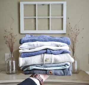Weekly reset. Image shows a small pile of laundry folded on an outstretched hand